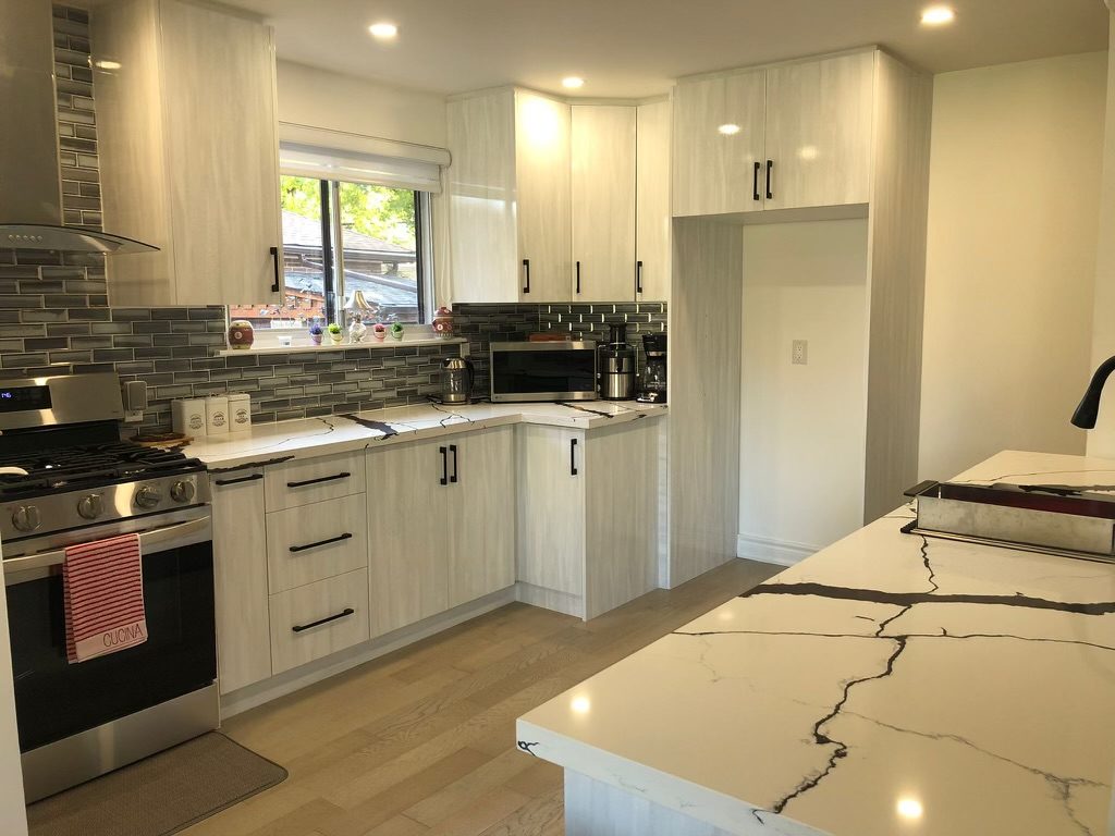 Custom cabinets and veined white countertops in a North York kitchen