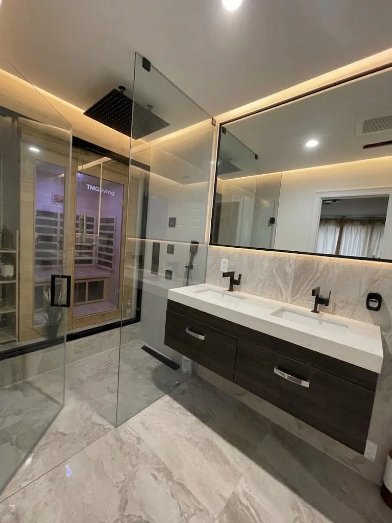 Renovated Toronto bathroom with glass shower, infrared sauna and floating double vanity with backlit mirror